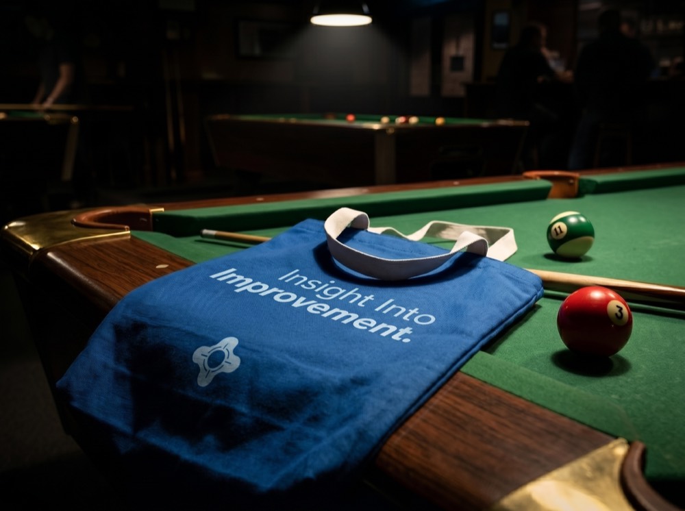 Poolgress tote bag beside a pool table