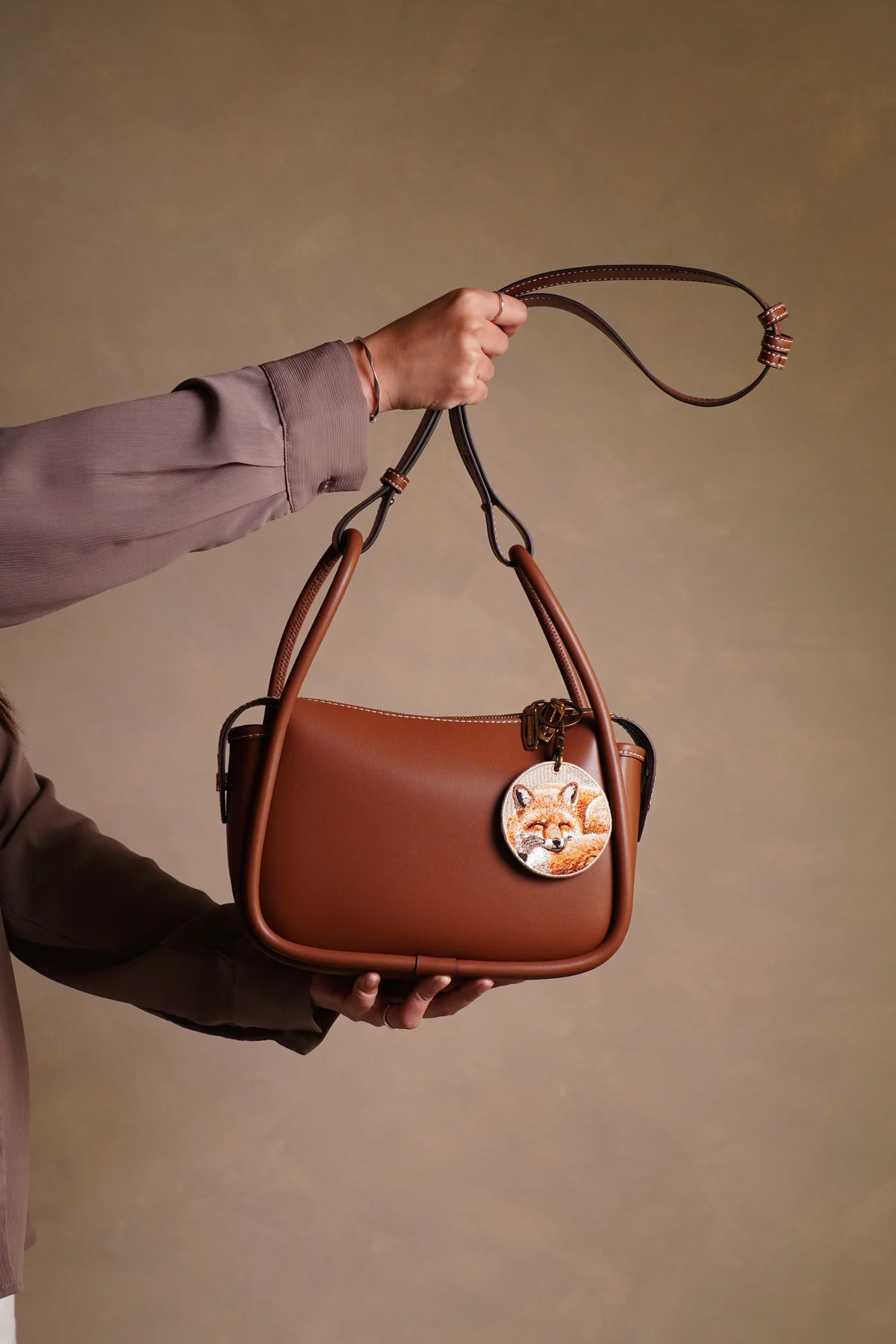 EMJOUR embroidered accessory on a handbag