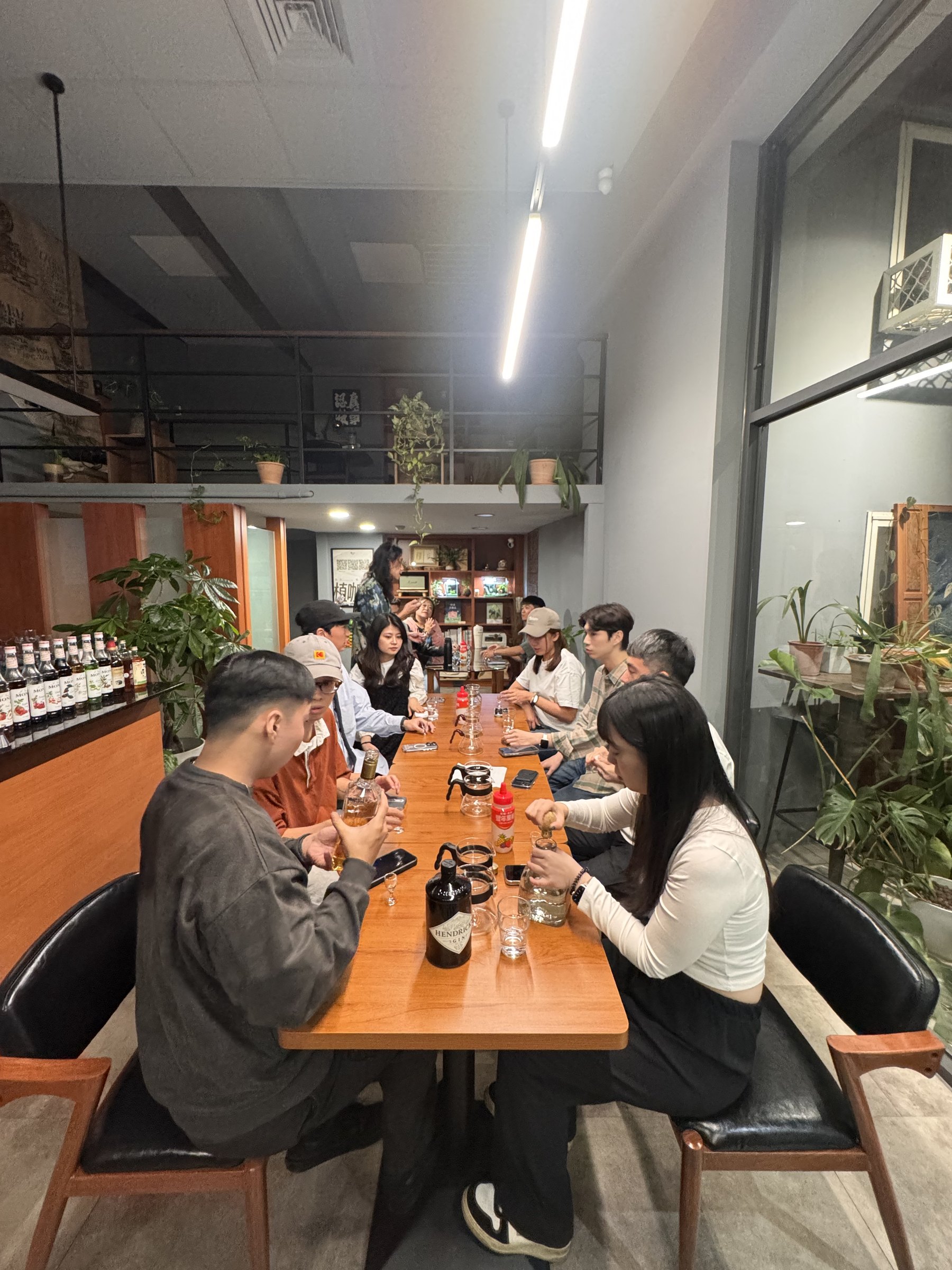 Guests taking part in a cocktail workshop around the communal table at Plants Cafe