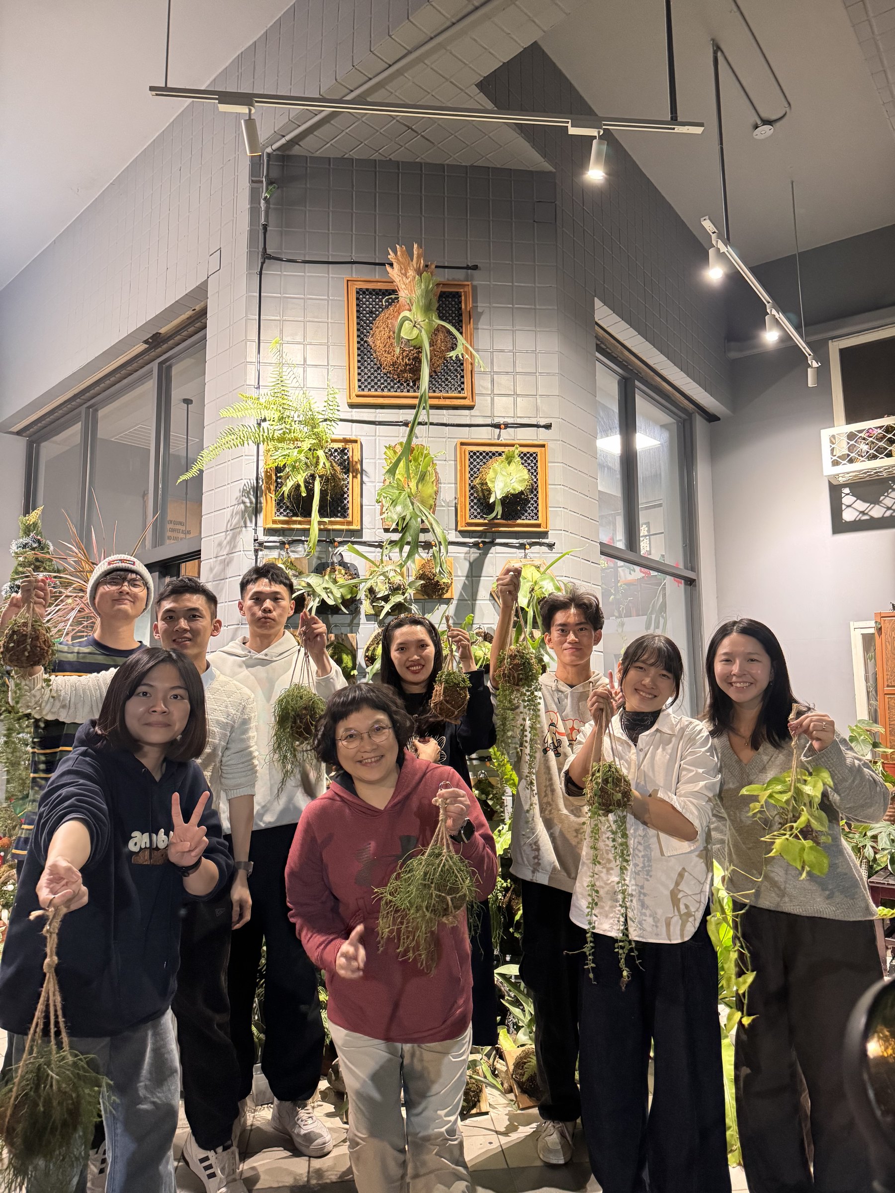Participants holding their finished staghorn fern arrangements at Plants Cafe
