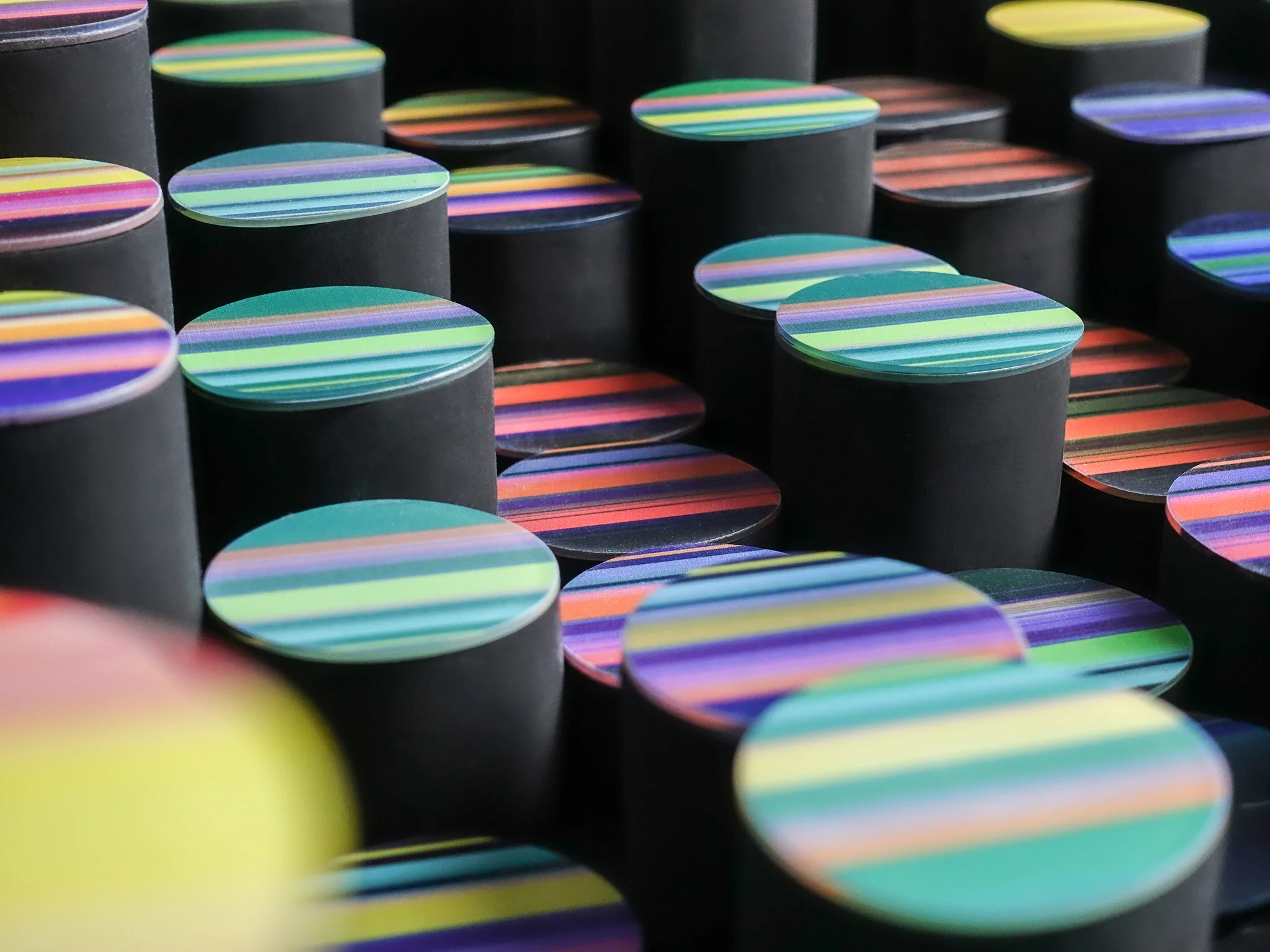 Close-up of raised textile forms with colorful striped tops